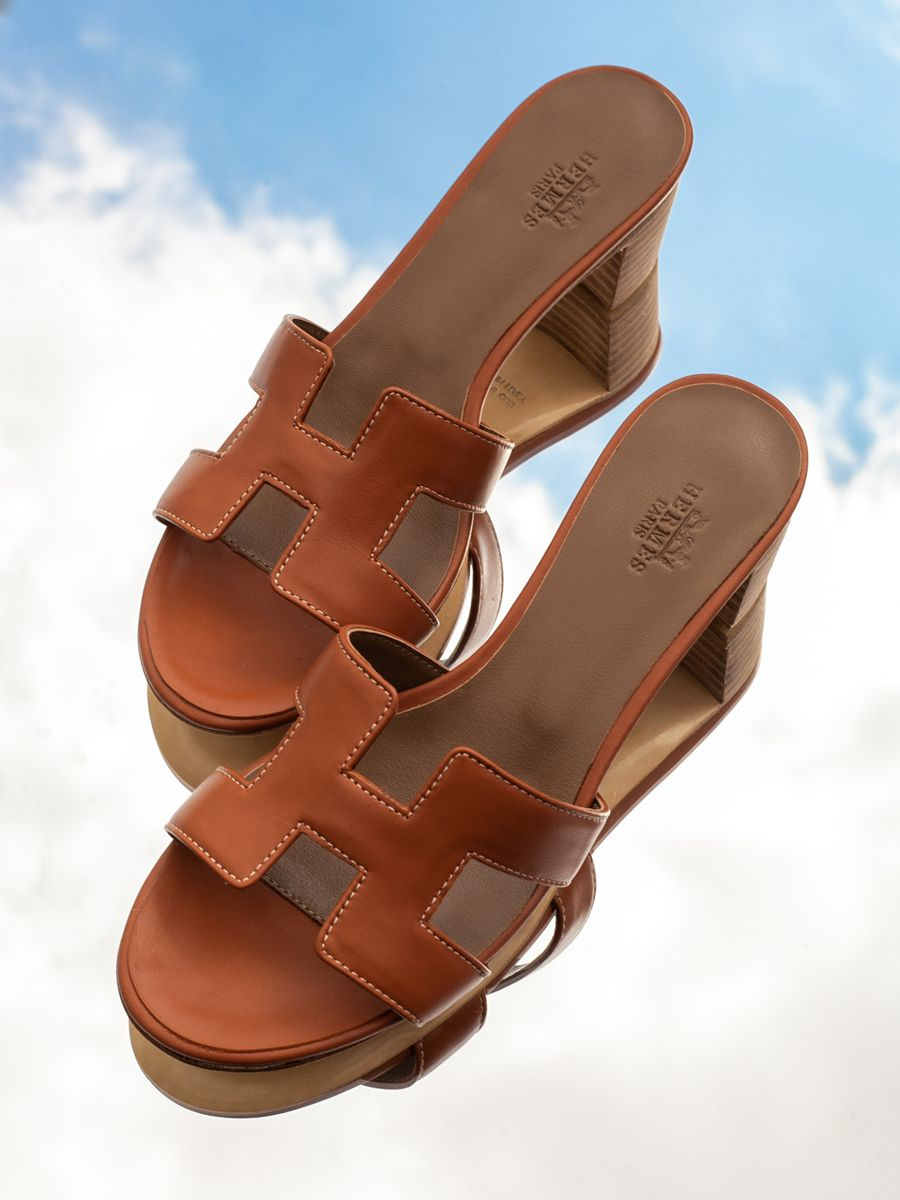 Реплика премиального качества модели Hermes Oran Sandal культового бренда Hermes из натуральной кожи удовлетворит даже ценителей, хорошо знающих дорогие оригиналы. Реплика класса АА шлепанцы Эрмес Оран неотличимая от оригинала - основа летнего гардероба, икона моды, дорогая обувь высочайшего качества. Созданные с превосходным мастерством и вниманием к деталям, эти уникальные коричневые сандалии сочетают в себе роскошный дизайн и непревзойденный комфорт. Шлепки из натуральной телячьей кожи выполнены с использованием инновационных технологий, они являются точной копией оригинала, воплощая в себе изысканный стиль и надежность. Культовая вещь, базовые босоножки для любого гардероба, самая популярная модель известного бренда - отличный выбор для тех, кто ценит роскошь и утонченность в каждой детали своего образа.   Преимущество нашего магазина перед другими магазинами, продающими люксовые реплики - анонимность покупки, возможность примерки, защищенность покупки сервисом Озон. Все товары в наличии в России. Люксовые копии вручную проверены нашими экспертами и сравнены с оригинальными изделиями.   В комплект входит коробка (копия оригинала), красивый бумажный пакет, 2 текстильных сумки - пыльника, брендированная карточка и открытка.  Обращаем ваше внимание, что все элементы сандалии, включая подошву, изготовлены из телячьей кожи. Кожаная подошва и кожаная часть каблука покрыты защитной пленкой, перед началом носки удалите пленку (смотрите видео). Для укрепления кожаной подошвы обуви рекомендуется установить профилактику в обувной мастерской. Профилактика представляет собой тонкую резиновую накладку, вырезанную в точном соответствии с очертаниями подошвы обуви. Она приклеивается к подошве очень прочным влагостойким клеем.