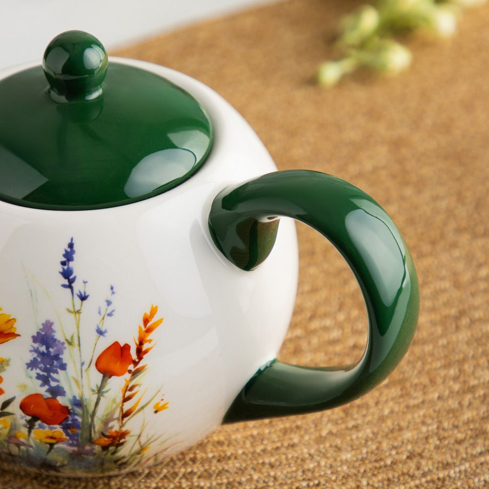 Материал чайника - керамика, что делает его экологически чистым и безопасным для здоровья. Керамический чайник не впитывает запахи, легко моется в посудомоечной машине и сохраняет свой первоначальный вид на долгие годы. Плотная крышка чайника надежно сохраняет температуру заварки, позволяя вам наслаждаться ароматным чаем в любое время. Дизайн чайника "Полевые Цветы" выполнен в летнем принте, который создает атмосферу тепла и уюта. Он прекрасно впишется в любой интерьер, добавив ярких красок и уютных акцентов. Удобная ручка обеспечит комфортное использование чайника, а его гармоничная округлая форма придаст столу особенный шарм.