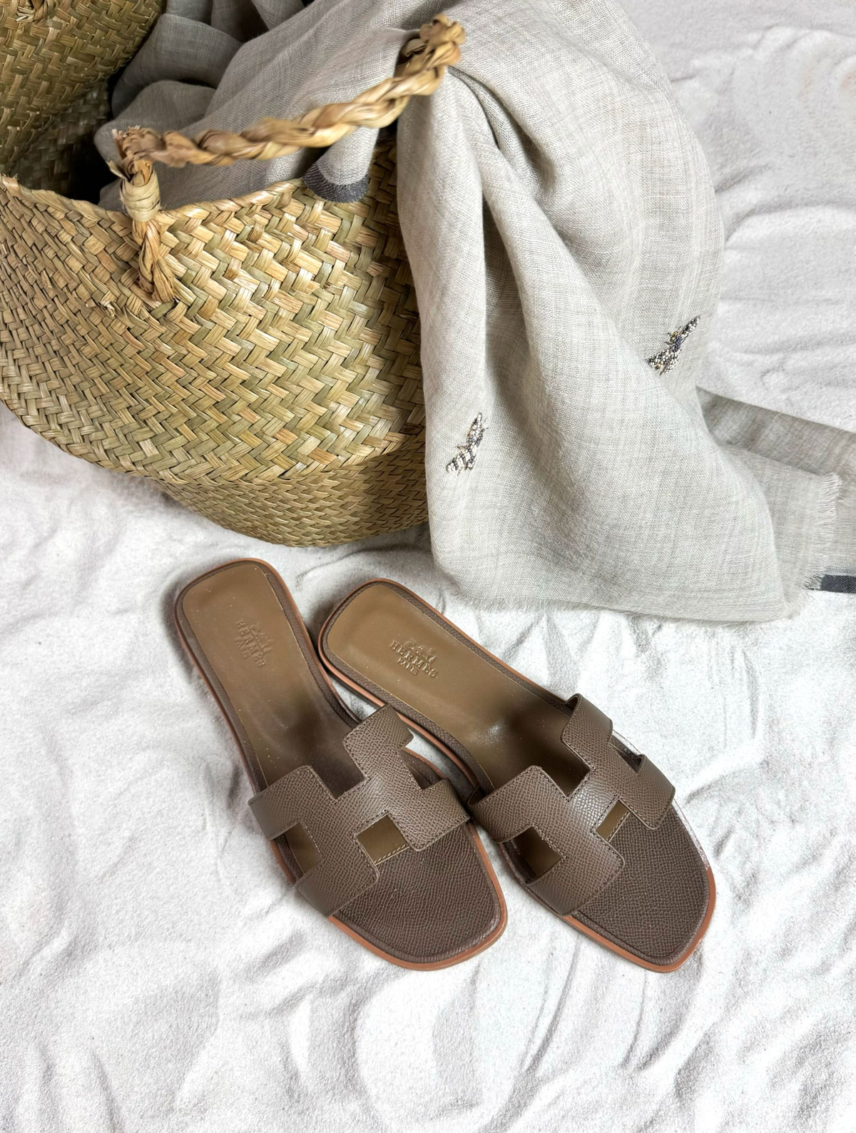 Реплика премиального качества модели Hermes Oran Sandal культового бренда Hermes из натуральной кожи удовлетворит даже ценителей, хорошо знающих дорогие оригиналы. Реплика класса АА шлепанцы Эрмес Оран неотличимая от оригинала - основа летнего гардероба, икона моды, дорогая обувь высочайшего качества. Созданные с превосходным мастерством и вниманием к деталям, эти уникальные коричневые сандалии сочетают в себе роскошный дизайн и непревзойденный комфорт. Шлепки из натуральной телячьей кожи выполнены с использованием инновационных технологий, они являются точной копией оригинала, воплощая в себе изысканный стиль и надежность. Культовая вещь, базовые босоножки для любого гардероба, самая популярная модель известного бренда - отличный выбор для тех, кто ценит роскошь и утонченность в каждой детали своего образа.   Преимущество нашего магазина перед другими магазинами, продающими люксовые реплики - анонимность покупки, возможность примерки, защищенность покупки сервисом Озон. Все товары в наличии в России. Люксовые копии вручную проверены нашими экспертами и сравнены с оригинальными изделиями.   В комплект входит коробка (копия оригинала), красивый бумажный пакет, 2 текстильных сумки - пыльника, брендированная карточка и открытка.  Обращаем ваше внимание, что все элементы сандалии, включая подошву, изготовлены из телячьей кожи. Кожаная подошва и кожаная часть каблука покрыты защитной пленкой, перед началом носки удалите пленку (смотрите видео). Для укрепления кожаной подошвы обуви рекомендуется установить профилактику в обувной мастерской. Профилактика представляет собой тонкую резиновую накладку, вырезанную в точном соответствии с очертаниями подошвы обуви. Она приклеивается к подошве очень прочным влагостойким клеем.