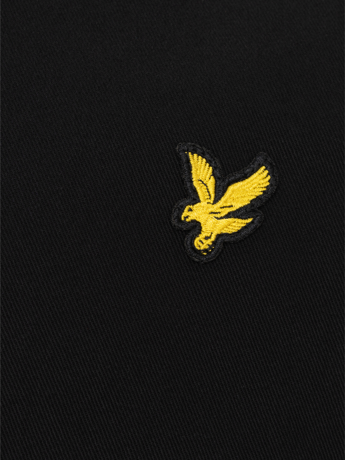 Фирменный логотип Lyle & Scott Golden Eagle  ﻿Вышитая эмблема золотого орла с черным кантом - характерный отличительный знак для основной коллекции бренда.